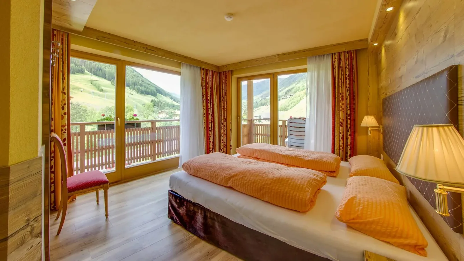 Schlafzimmer im Appartement Typ B Kristall mit großen Fenstern zum Balkon